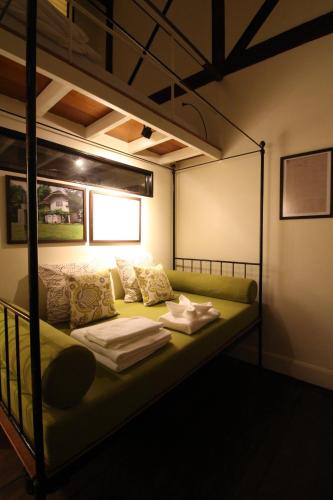 a room with a bunk bed with a green couch at Baan Luang Rajamaitri Historic Inn in Chanthaburi
