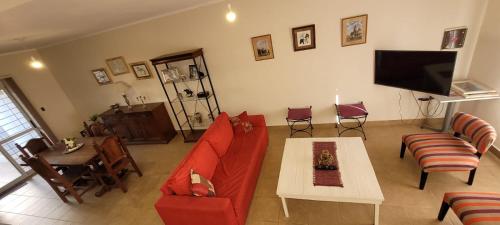 uma sala de estar com um sofá vermelho e uma mesa em Dúplex amplio y luminoso em San Fernando del Valle de Catamarca