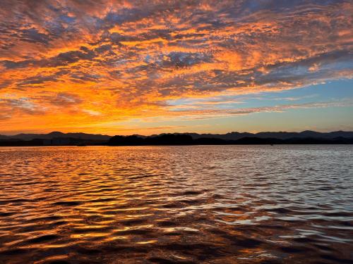 a sunset over a large body of water at 白浜貸別荘2-79 in Shirahama