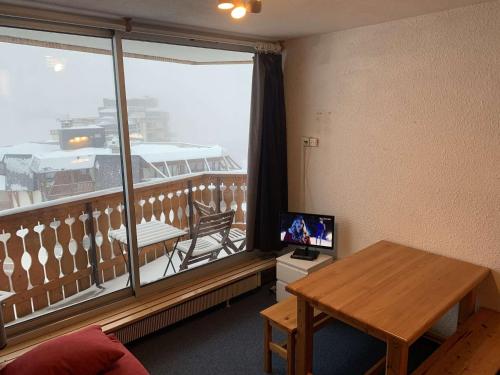 Cette chambre dispose d'un balcon avec une table et une télévision. dans l'établissement Studio cosy à Val Thorens, idéal pour 3 pers., balcon sud-ouest, proche commerces et remontées mécaniques - FR-1-637-41, à Val Thorens