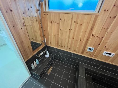 een badkamer met een douche en een tegelvloer bij 白浜貸別荘2−43 in Kanayama