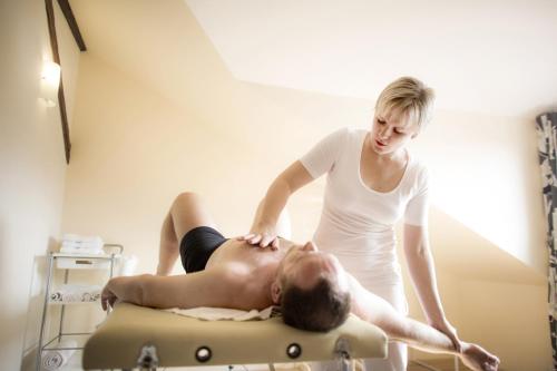 a woman is giving a man a massage at Rezidence Mandragora in Pardubice