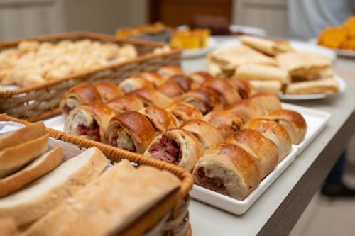 uma mesa coberta com diferentes tipos de pastelarias e pão em HOTEL EXECUTIVO em Parauapebas