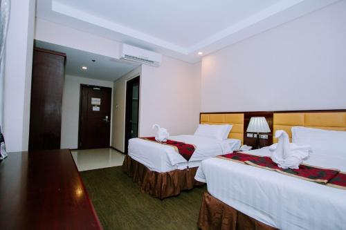 Postel nebo postele na pokoji v ubytování Palawan Uno Hotel