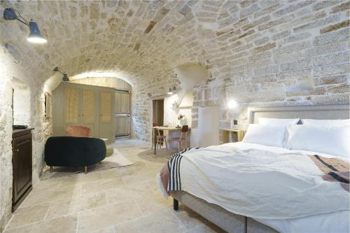 um quarto com uma cama e uma parede de tijolos em Les Confidentielles em Balaruc-le-Vieux