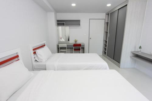 a bedroom with two beds and a desk at Matasiri Residence in Ban Bang Phang