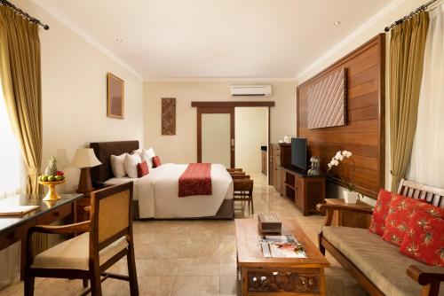 a hotel room with a bed and a couch at Amarta Beach Retreat by Nakula in Tabanan