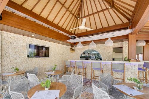 a restaurant with tables and chairs and a bar at Puspa Ayu Villas & Apartments in Kuta