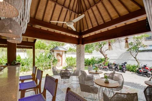 an outdoor patio with tables and chairs and motorcycles at Puspa Ayu Villas & Apartments in Kuta
