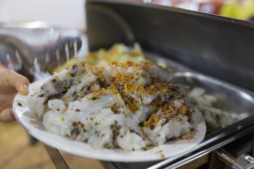 una persona che tiene in mano un piatto di cibo di London Sa Pa Hotel a Sa Pa