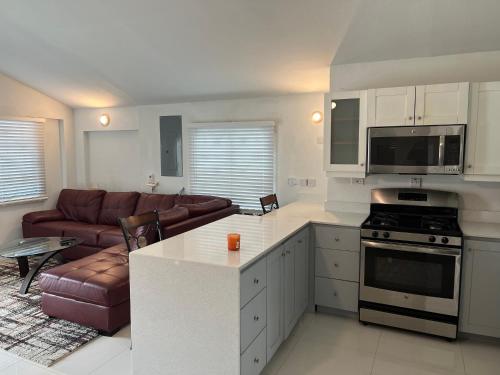 een keuken en een woonkamer met een bank en een fornuis bij Joy Estate Rooftop Pool n View unit #1 in Falmouth