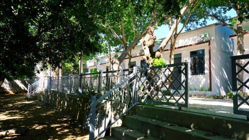 a woman standing on a fence next to a building at Hải An Homestay - Garden by the Beach in Phan Rang