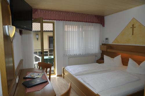 a hotel room with a bed and a table with a laptop at Gasthof Zur Krone in Mitteleschenbach