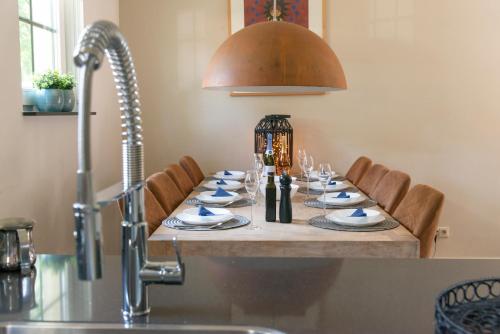 una mesa con platos y copas de vino. en Spacious luxury holiday home/villa - Ruime luxe vakantiewoning/-Villa en Ede