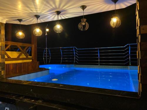 a large blue pool in a gym with lights at Pousada Mirante do César in Bombinhas
