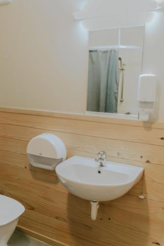a bathroom with a white sink and a mirror at Waitomo Village Chalets home of Kiwipaka in Waitomo Caves