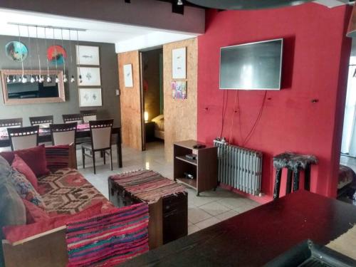 sala de estar con sofá y pared roja en Espectacular departamento en zona residencial en Mendoza
