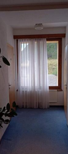 a room with a large window with white curtains at Garni Fluela Susch in Sur
