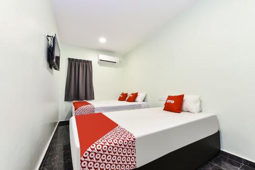 een slaapkamer met 2 bedden en een raam bij OYO 90445 Th Hotel in Bahau
