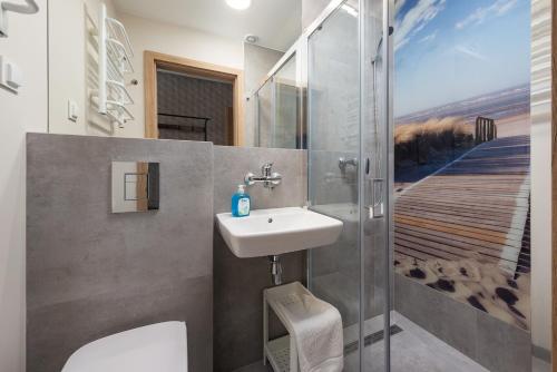 a bathroom with a toilet and a sink and a shower at Wojciech-pokoje PREMIUM-śniadania bufet-2 sale zabaw-możliwość wyżywienia in Władysławowo