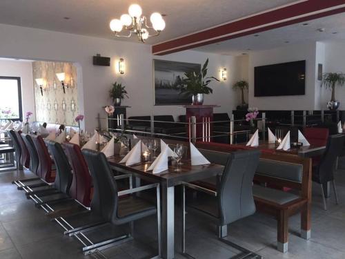 a dining room with a long table and chairs at Hotel ZeitZeichen in Pulheim