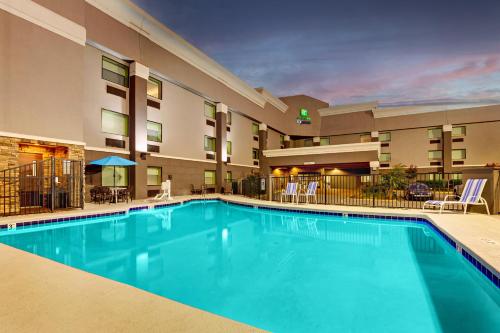 een zwembad voor een hotel met tafels en stoelen bij Holiday Inn Express Nashville W-I40, an IHG Hotel in Nashville