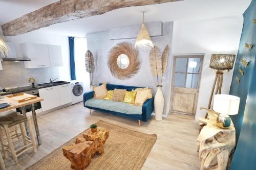 sala de estar con sofá azul y cocina en Appartements Premium en Hyper Centre Ville, en Brignoles