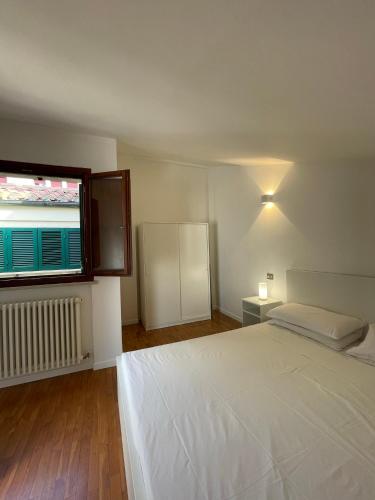 a bedroom with a large white bed and a window at Casa Apolloni 40 in Fano