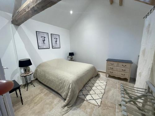 een slaapkamer met een bed en een dressoir bij Gîte de l’abbaye in Saint-Jean-aux-Bois