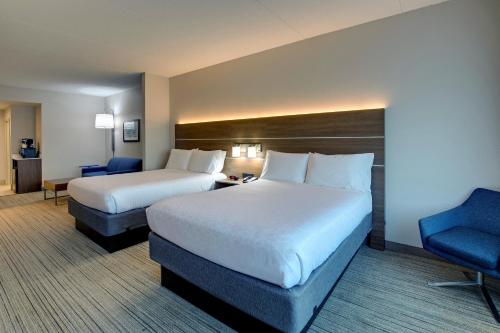 a hotel room with two beds and a chair at Holiday Inn Express Nashville-Opryland by IHG in Nashville