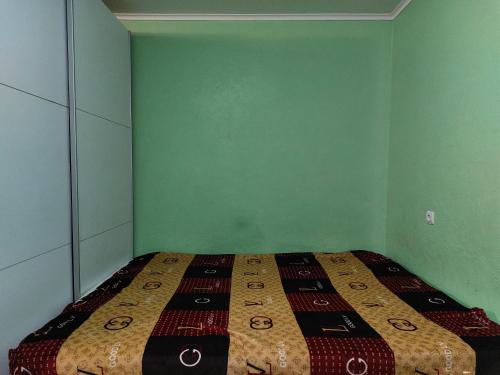 1 dormitorio con 1 cama en una habitación verde en министудия, в которой есть абсолютно всё, en Cherníhiv