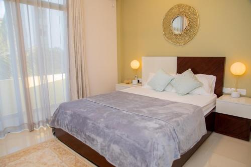 a bedroom with a bed with a mirror and a window at ARON'S Lavinia RUBY in Mount Lavinia