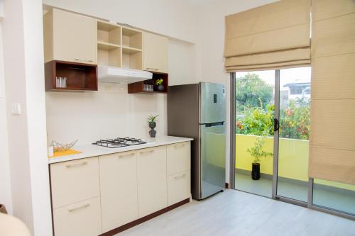uma cozinha com armários brancos e uma porta que leva a um pátio em ARON'S Lavinia RUBY em Mount Lavinia