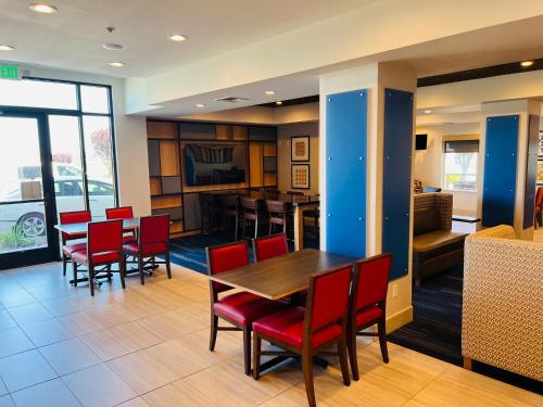 a dining room with a table and red chairs at Holiday Inn Express & Suites Salinas by IHG in Salinas