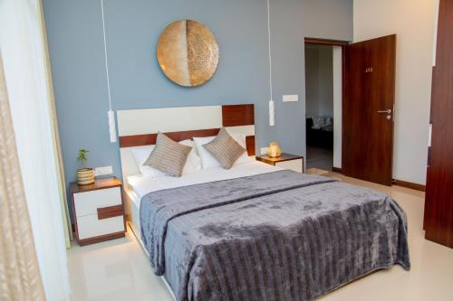 a bedroom with a large bed with a blue wall at ARON'S Lavinia TOPAZ in Mount Lavinia