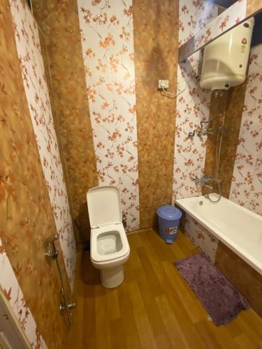 a bathroom with a toilet and a sink and a tub at Lake Victoria Houseboats in Srinagar