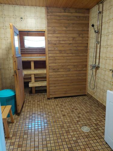 a bathroom with a shower and a wooden door at Punavilla majoitus TASANKO in Säkylä
