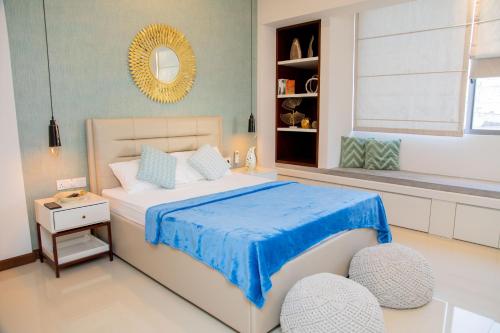 a bedroom with a large bed with a blue blanket at ARON'S Lavinia EMERALD in Mount Lavinia