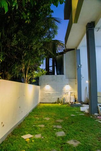 a backyard of a house with a grass yard at ARON'S Lavinia TOPAZ in Mount Lavinia