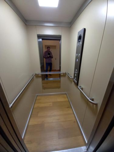 um homem parado num corredor num elevador em Alte Mühle em Holzminden