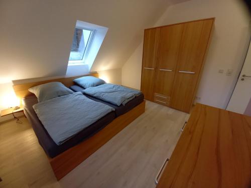 a small bedroom with a bed and a cabinet at Alte Mühle in Holzminden