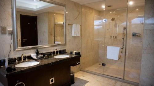a bathroom with two sinks and a shower at Amazing Duplex Suite Available in Accra