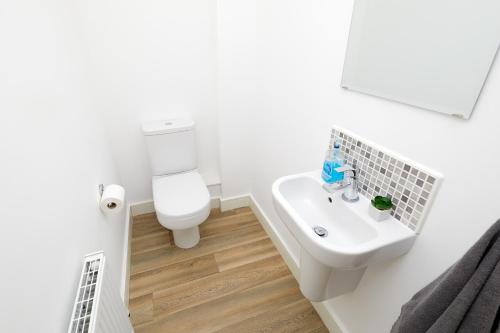 a bathroom with a white toilet and a sink at Royal Derby Hospital Mickleover Town House in Derby