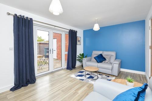 a living room with blue walls and a couch at Royal Derby Hospital Mickleover Town House in Derby