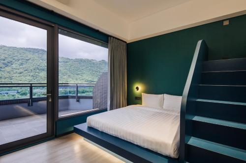 a bedroom with a bed and a large window at OA HOTEL Wushih Marina in Toucheng