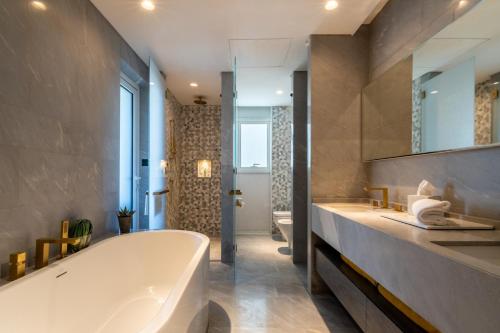 Un baño con una bañera grande y un lavabo. en South Residence FIVE Palm - Luxurious Three Bedroom, en Dubái
