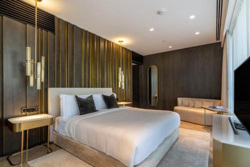Un dormitorio con una gran cama blanca y un sofá. en South Residence FIVE Palm - Luxurious Three Bedroom, en Dubái