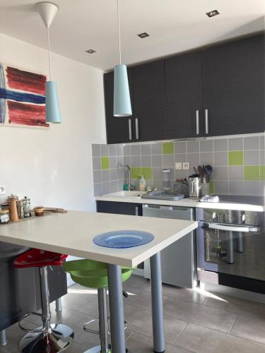 - une cuisine avec une table et une plaque bleue dans l'établissement STU_DUO au Plan d’eau., à Embrun