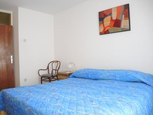 a bedroom with a bed with a blue comforter at Apartment Rita RM in Portorož