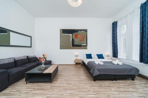 een woonkamer met een bank en een bed bij Barbakan Residence Old Town in Krakau